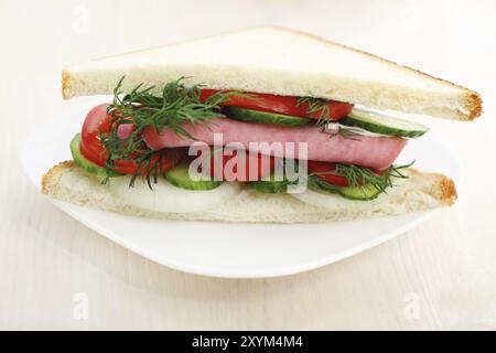 Leckeres Sandwich mit Schinken und weißem Teller Stockfoto