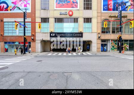 Leute gehen am Eingang des Eaton Centre Parkplatzes vorbei, mit Blick auf die Fassade der Gebäude. Stockfoto