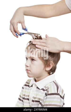 Frau Hand hält eine Schere, die Kinderhaare schneidet Stockfoto