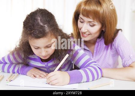 Kleines Mädchen mit und ihre Mutter malen. Innenporträt Stockfoto