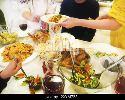 Familie beim Abendessen sitzen zusammen am Tisch. Abendessen mit der Familie gemeinsam genießen. Stockfoto