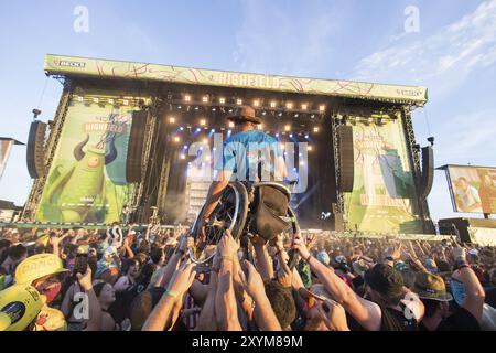 Ein Rollstuhlfahrer wird während der Aufführung der Band Feine Sahne Fischfilet beim Highfield Festival am Samstag in Stoe durch das Publikum getragen Stockfoto