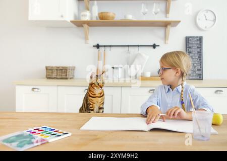 Freudige wenig glücklich sein in der Küche malen und lächelnd zu ihr Bengal cat Stockfoto