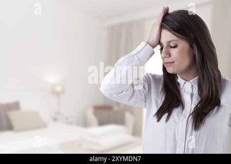 Mädchen Hand auf ihre Stirn in ein Zeichen der Mühe in einem Haus Stockfoto