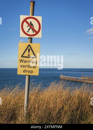 Zeichen: Warnung vertikale Drop, Whitby, North Yorkshire, England, UK gesehen Stockfoto