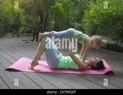 Mutter und Tochter Übung Yoga im Freien zu praktizieren. Gesunde Lebensweise Stockfoto