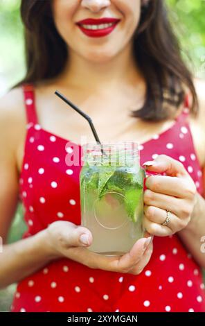 Junge brünette Frau mit einem marmeladenglas in ihrer Hand mit einem Mojito. Sommer trinken Konzept Stockfoto