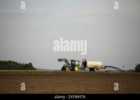 Traktor auf einem Feld, das Gülle verteilt Stockfoto