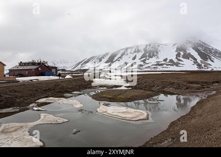 Schneebedeckte Berge und Wetterstation an einem nebeligen Tag in NY Alesund, Svalbard Inseln, Norwegen, Europa Stockfoto