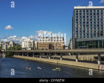 Fluss mit Paddelbooten und modernen Wolkenkratzern an einem sonnigen Tag, stockholm, ostsee, schweden, skandinavien Stockfoto