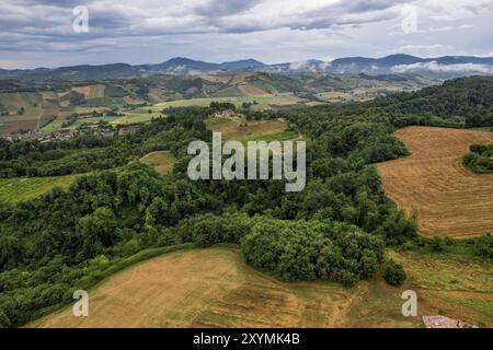 Luftaufnahme der toskanischen Landschaft mit bewölktem Himmel und bewirtschafteten Feldern und Wäldern. Castell'Arquato, Arda Valley, PC, Italien, Europa Stockfoto