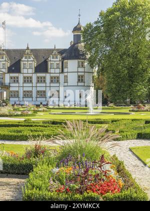 Historisches Schloss mit gepflegten Gärten, einem Brunnen und blühenden Pflanzen entlang der Wege, Schloss Neuhaus, Deutschland, Europa Stockfoto