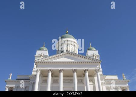 Weiße Kathedrale mit beeindruckenden Säulen und grünen Kuppeln vor tiefblauem Himmel, Helsinki, Finnland, Europa Stockfoto