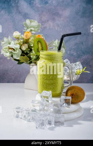 Erfrischendes Kiwi Smoothie mit Blumendekor Stockfoto