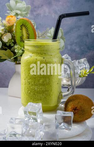 Erfrischendes Kiwi Smoothie mit Blumendekor Stockfoto