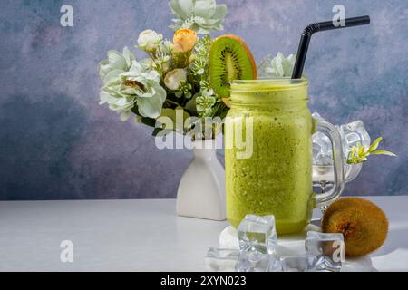 Erfrischendes Kiwi Smoothie mit Blumendekor Stockfoto