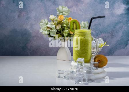 Erfrischendes Kiwi Smoothie mit Blumendekor Stockfoto