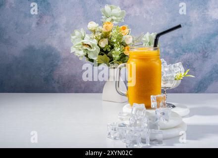 Erfrischender PfirsichSmoothie mit Eis und Blumen Stockfoto