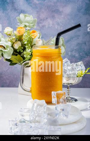 Erfrischender PfirsichSmoothie mit Eis und Blumen Stockfoto