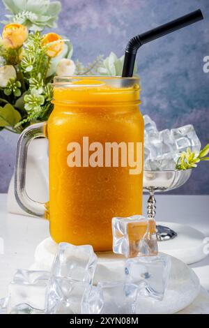 Erfrischender PfirsichSmoothie mit Eis und Blumen Stockfoto