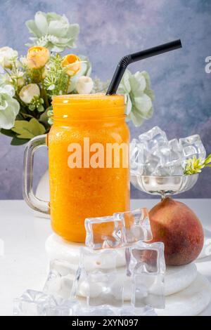 Erfrischender PfirsichSmoothie mit Eis und Blumen Stockfoto