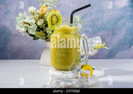 Erfrischendes Kiwi Smoothie mit Blumendekor Stockfoto