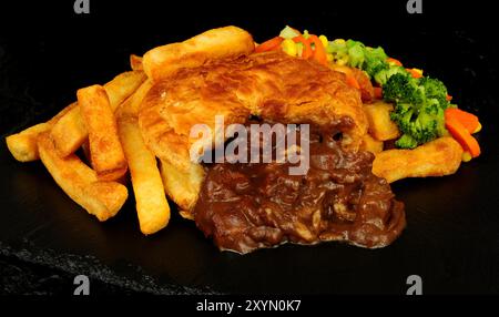 Steak und Soße Blätterteigkuchen und Pommes Frites mit gemischtem Gemüse Stockfoto