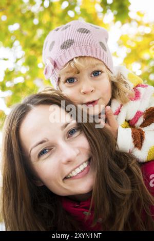 Niedriger Blickwinkel auf glückliche, lächelnde Familie vor verschwommenem Herbstblatthintergrund Stockfoto