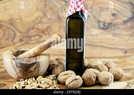 Walnuss (Juglans regia), ganze und gekrackte Walnüsse, Walnussöl und Mörtel Stockfoto