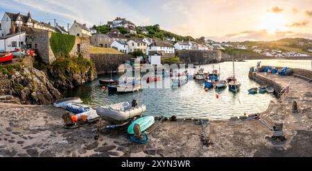 COVERACK, CORNWALL, GROSSBRITANNIEN - 9. JUNI 2024. Panoramablick auf die Landschaft der traditionellen kornischen Fischerboote, die im Gezeitenhafen der malerischen Fischerei vor Anker liegen Stockfoto