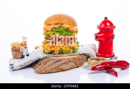 Gegrillter Chicken Burger mit frischem Gemüse auf einem Holzbrett Stockfoto