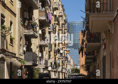 Enge Gasse von Häusern im Viertel Barceloneta, im Hintergrund moderne Wolkenkratzer in Barcelona, Spanien, Europa Stockfoto