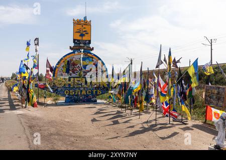 DONEZK Reg, UKRAINE - 29. August 2024: Flaggen der Brigaden, die das Donezk-Gebiet in der Nähe der Stele am Eingang zum Donezk-Gebiet verteidigen Stockfoto