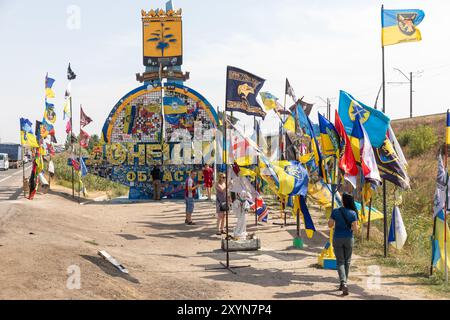 DONEZK Reg, UKRAINE - 29. August 2024: Flaggen der Brigaden, die das Donezk-Gebiet in der Nähe der Stele am Eingang zum Donezk-Gebiet verteidigen Stockfoto