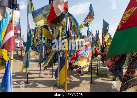 DONEZK Reg, UKRAINE - 29. August 2024: Flaggen der Brigaden, die das Donezk-Gebiet in der Nähe der Stele am Eingang zum Donezk-Gebiet verteidigen Stockfoto