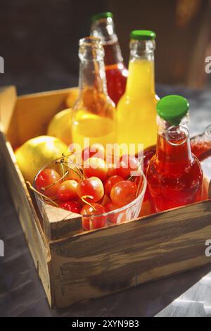 Limonade mit Kirsche, Birne und Zitrone in der Holzkiste auf dem Garten Picknick Stockfoto