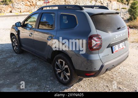 Kalkan, Türkei - 13. August 2024: 2024 Dacia Duster Nahaufnahme von hinten. Modernes graues Geländefahrzeug steht am Straßenrand in der Nähe der Bergstraße auf Stockfoto