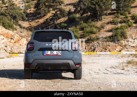 Kalkan, Türkei - 13. August 2024: Rückansicht des Dacia Duster 2024. Modernes graues Geländefahrzeug steht am Straßenrand in der Nähe der Bergstraße auf einer sonnigen Summe Stockfoto