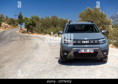 Kalkan, Türkei - 17. August 2024: Vorderansicht des Dacia Duster 2024. Modernes graues Geländefahrzeug steht auf der Straße in der Nähe der Bergstraße bei sonnigem Sommer Stockfoto