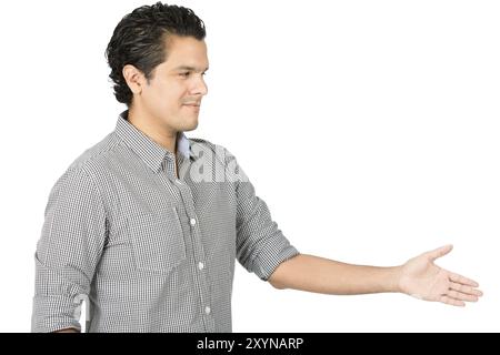 Gastfreundlicher, gut aussehender hispanischer Mann in lässigem Button-Down-Hemd, der sich ausdehnt und Handschlag bietet, direkt in die Kamera blickt, warm mit einem Auto begrüßt Stockfoto