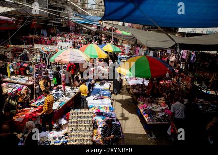 Khan Younis, Gazastreifen, Palästina. Mai 2022. Palästinenser kaufen auf einem lokalen Markt am Vorabend von Eid al-Fitr in der südlichen Stadt Khan Younis im Gazastreifen ein. Es ist eine Tradition für Muslime, am Ende des Ramadan Geschenke, neue Kleidung und Süßigkeiten zu kaufen, doch ist die Kaufkraft vieler Palästinenser in Gaza aufgrund der hohen Arbeitslosigkeit und der Armutsraten in der palästinensischen Enklave begrenzt Stockfoto