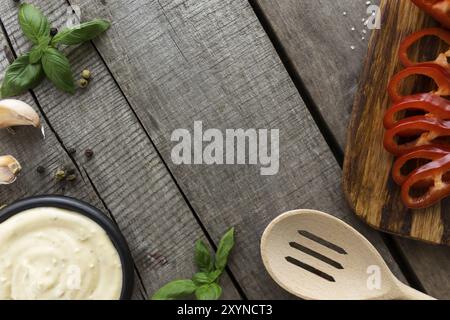 Konzeptionelle flache Lay. Herstellung von Knoblauch-Sahne-Sauce oder Kochen Käsesauce, Essen und Gewürzen, hausgemachte Mayonnaise, in Scheiben geschnitten roten süßen Papper auf Holz-Bac Stockfoto