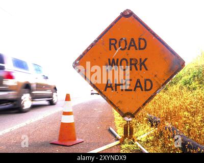 Ein Schild mit der Aufschrift Arbeit vor uns liegt ist vergeht ein schnelles Auto Stockfoto