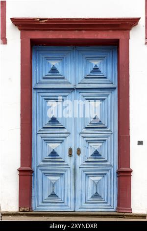 Alte und alte blaue historische Kirche Holztür in der Stadt Sabara, Minas Gerais mit seinem rostigen Metallteil Stockfoto