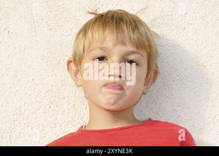 Der freche Junge streckt seine Zunge raus, der freche Junge streckt seine Zunge raus Stockfoto