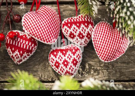 Rote Weihnachtsbaumdekorationen gerahmter grüner Zweig auf hölzernem Hintergrund Stockfoto