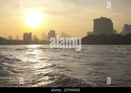 Sonnenaufgang über der Skyline der Innenstadt und dem Fluss Chao Phraya in Bangkok, Thailand, Asien Stockfoto