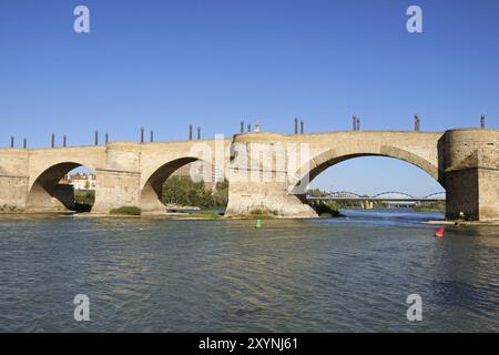 Steinbrücke (Puente de Piedra) über den Fluss Ebro in Saragoza, Spanien. Sie wird auch Lion Bridge genannt, weil zwei Paare von bronzenen Löwen auf Säulen pla sind Stockfoto