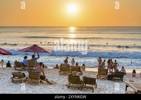 Surfer und Badende, Strand, Urlaub, Sonnenuntergang, Reisen, Strandurlaub, Tourismus, Abendsonne, Abendstimmung, entspannt, entspannen, Sonnenschirm, Sonnenschein, schön, Stockfoto