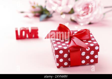 Retro Style red Polka Dots Geschenkbox, Rosen, Wort Liebe auf romantischen Pastell-hintergrund, Valentines Tag Konzept Stockfoto